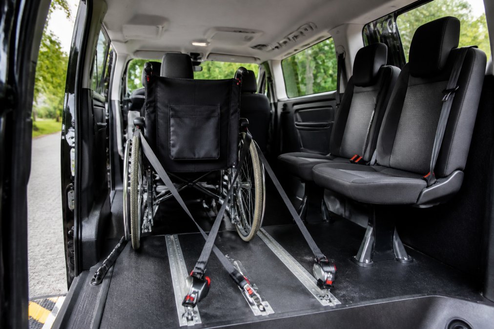 Interieur van rolstoeltaxi met zichtbare rolstoelvastzetsysteem, veiligheidsgordels, comfortabele zitplaatsen en moderne uitrusting, schoon en professioneel