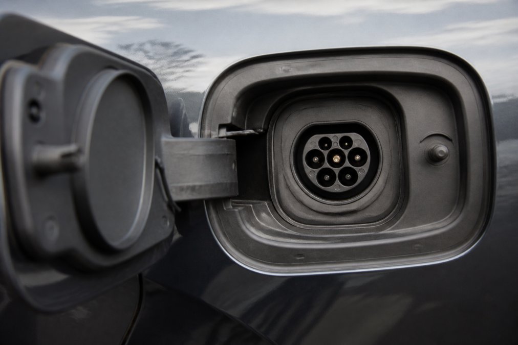 Närbild av V2L-laddningsporten på elbilen visar en ren och välskött kontakt utan synliga tecken på korrosion eller oxidation, med tydlig sikt på kontakterna.
