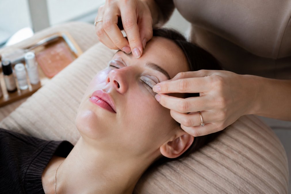 Hands applying silicone rods to natural lashes as one of the best lash lift kits alternatives at home.