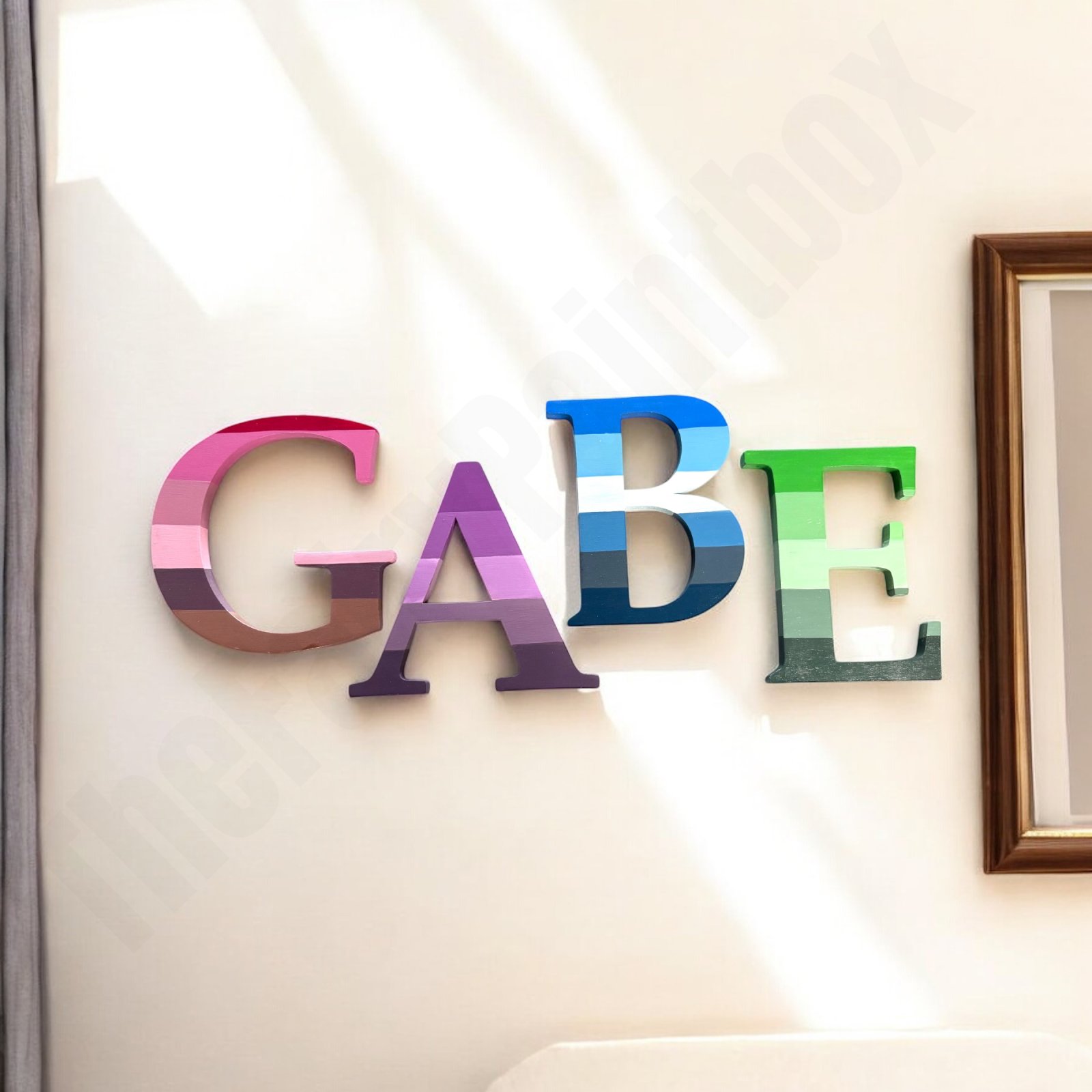 Color wheel painted wood letters spell baby’s name and hang on wall. Art themed room with rainbow of colors.