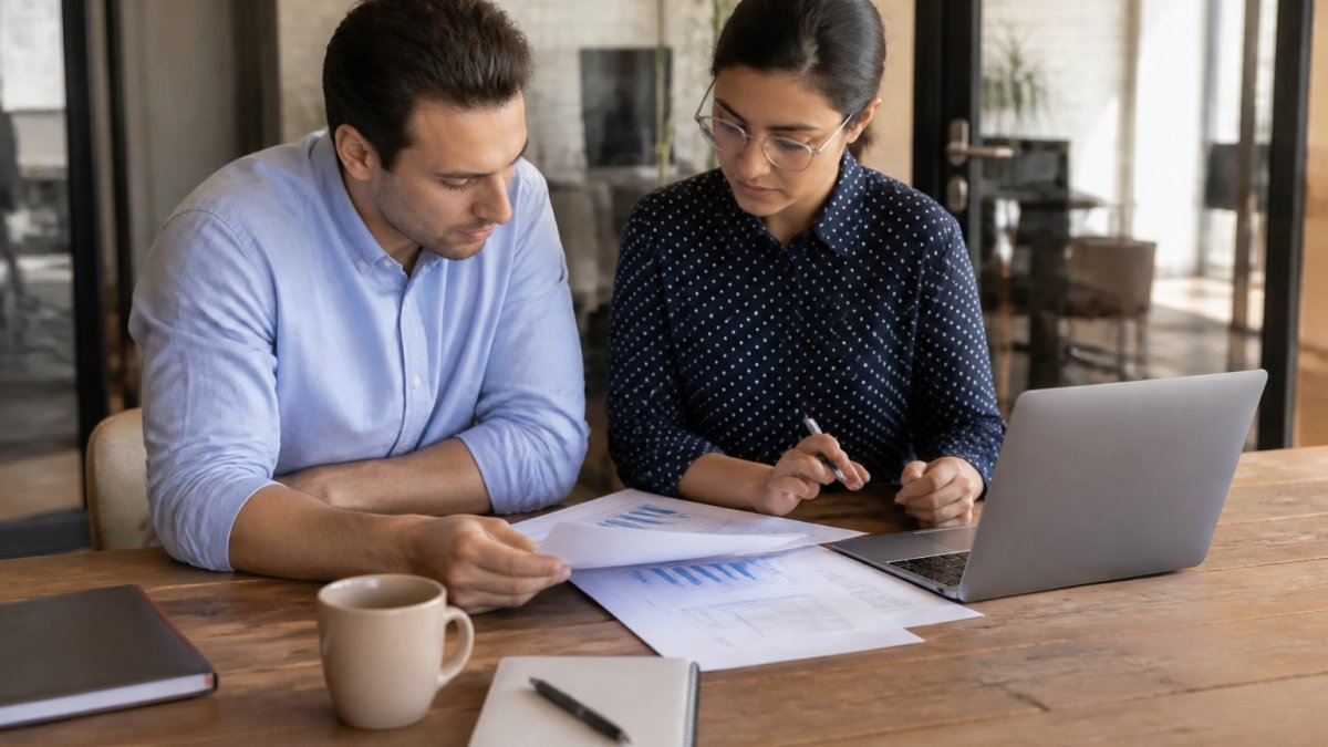 Founder and accountant reviewing a 90-day roadmap for scaling finance operations on a laptop dashboard in a startup office.