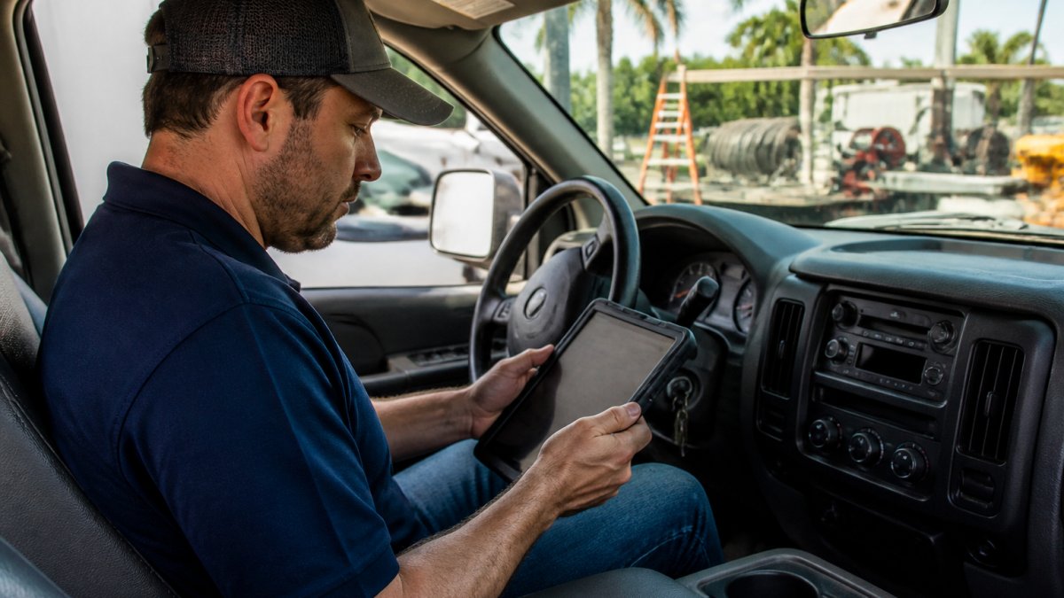 Field service technician using a tablet to manage work orders while scaling service operations from a mobile truck