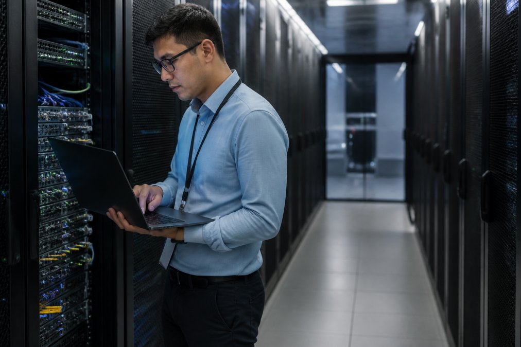 IT security professional reviewing access controls, authorization policies, and agent execution logs on multiple workstation displays in a secure operations center, with credential management systems visible in the background