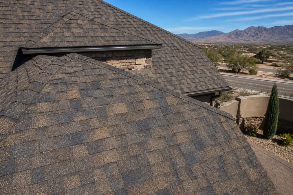 Close-up photograph of a newly installed Sedona Canyon shingle roof on a desert-style home in El Paso, showing the multi-dimensional brown, gray, and tan granule blend under bright sunlight