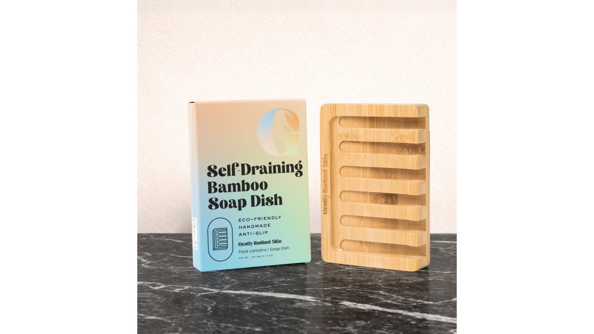A bathroom counter with several unwrapped shea butter soap bars arranged in a row, a self-draining bamboo soap dish, and a folded cotton washcloth in soft natural light