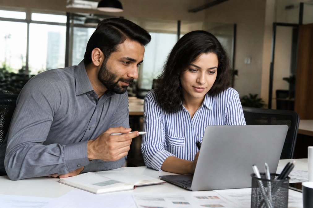 SEO Provider in India: How to Choose the Right Agency | Brain Point Business owner and consultant reviewing SEO provider performance metrics on a laptop in a bright office