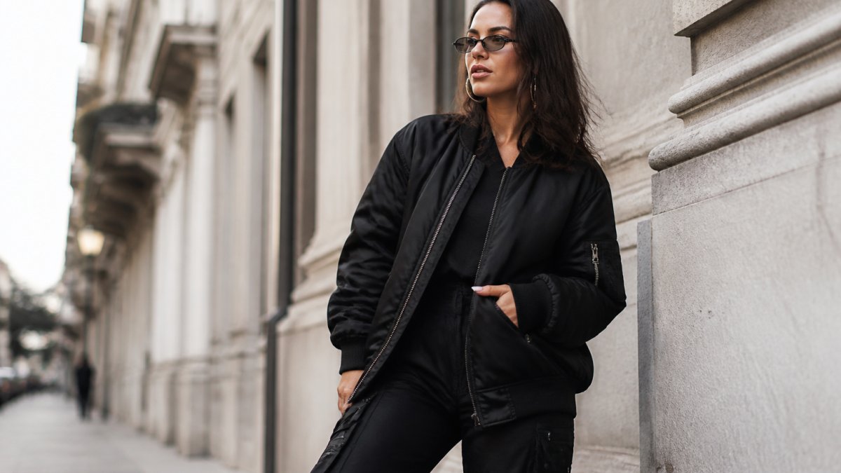 Confident woman wearing bold Viadellerose streetstyle pieces in a modern urban setting, showcasing sophisticated aesthetic and craftsmanship of the collection
