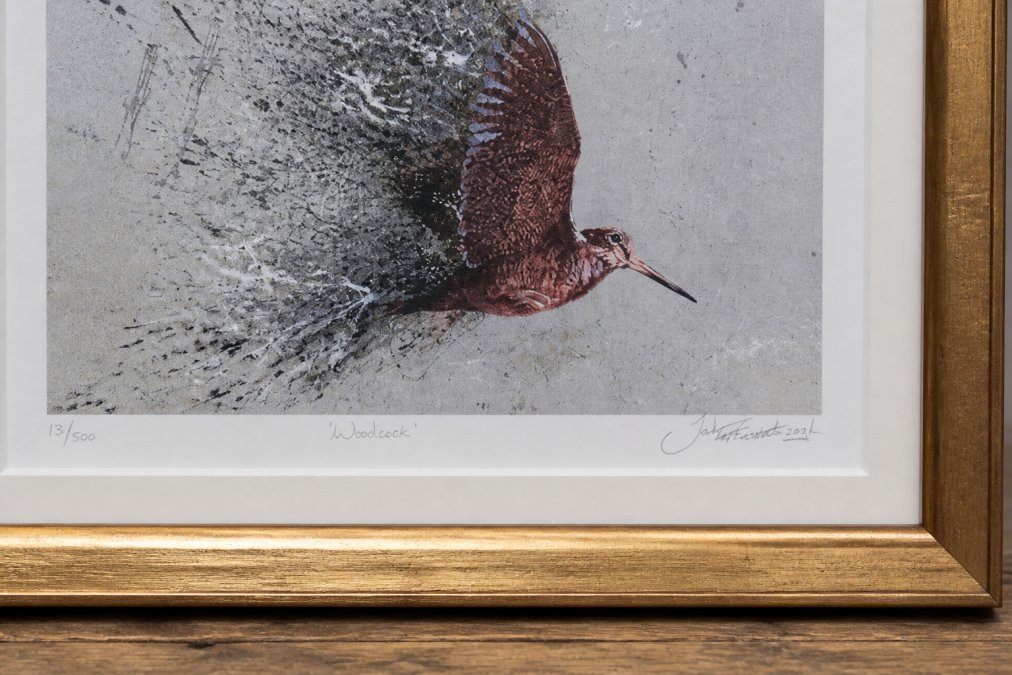 Close-up of a hand-signed and numbered framed woodcock and partridge print with gold frame, showing the artist's signature in pencil and handmade frame detail