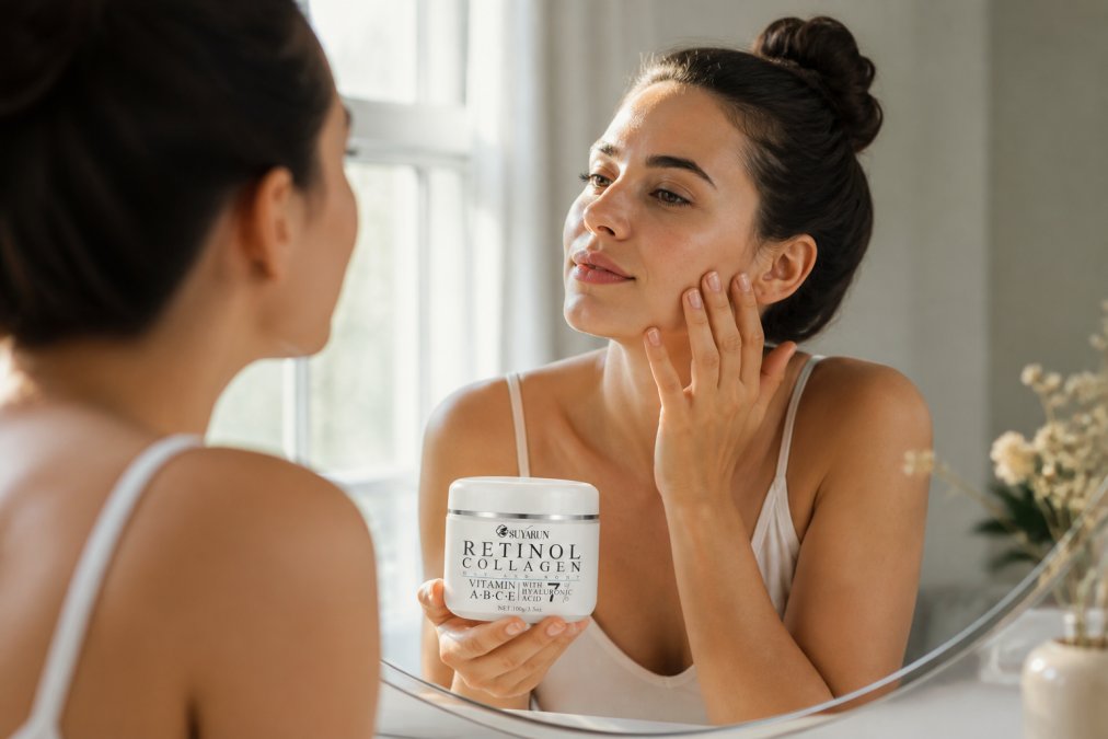 Woman examining her skin in natural window light while holding a skincare product, looking closely at her reflection in a mirror, assessing texture and tone improvements