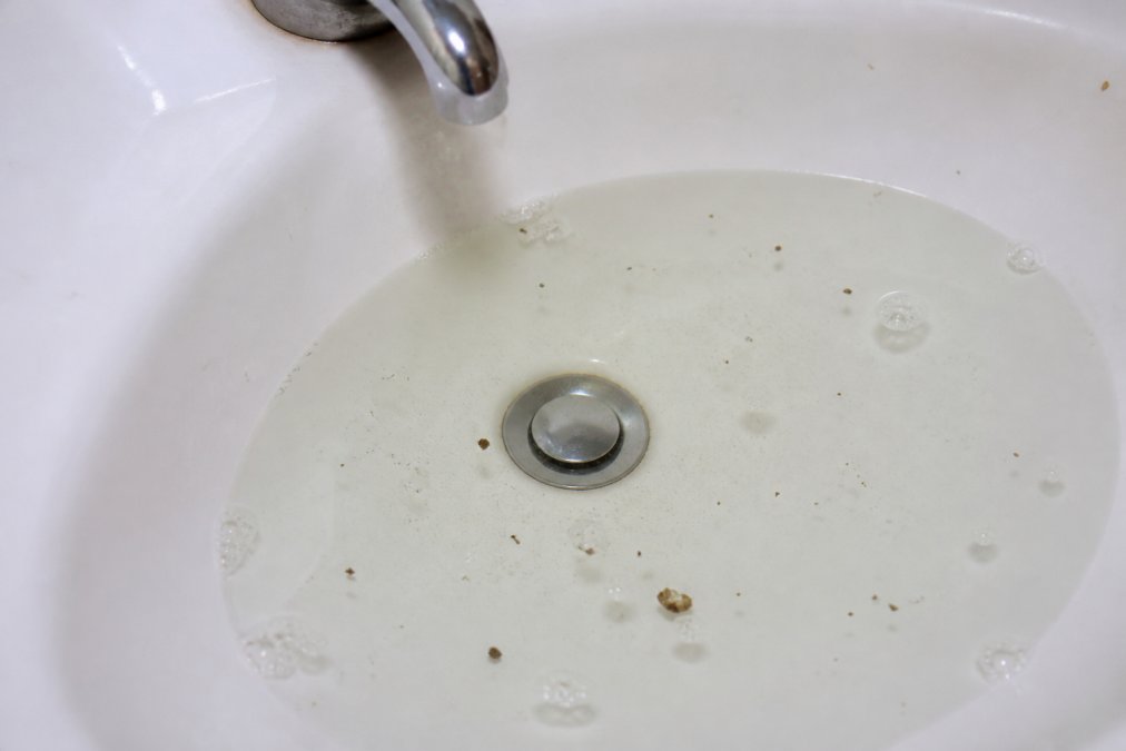 Infographic illustrating how clogged pipes cause water backup, highlighting the need for professional drain cleaning.