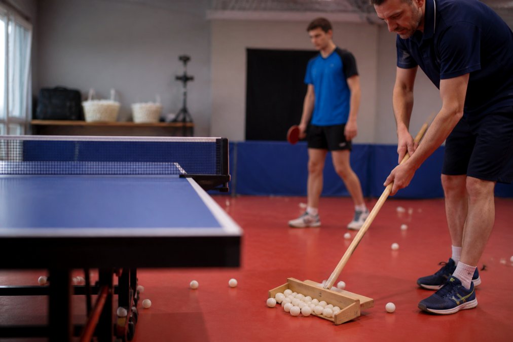 Diagram showing a step-by-step process to organize table tennis equipment using a wooden ball scoop on a blue table.