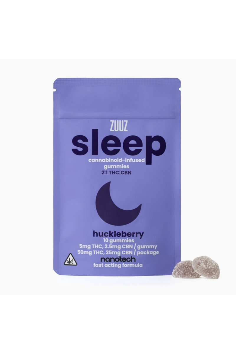 A dimly lit bedroom at night with a small glass jar of amber gummies resting on a wooden nightstand beside a glass of water and a sleep mask, warm soft lamplight glowing in the background