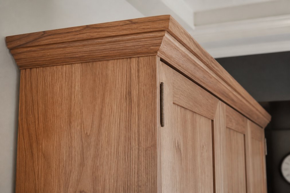 Close-up of solid hardwood murphy bed cabinet showing wood grain texture, joinery details, and premium finish quality in natural lighting