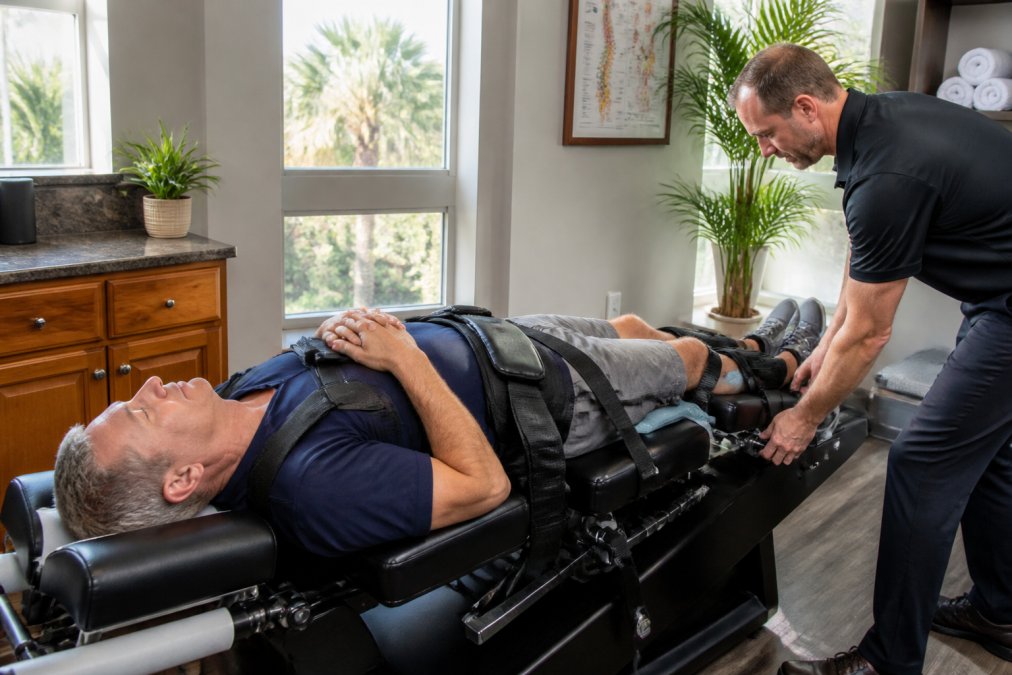 Diagram of the spinal decompression process at a Naples clinic showing a patient on a motorized traction table