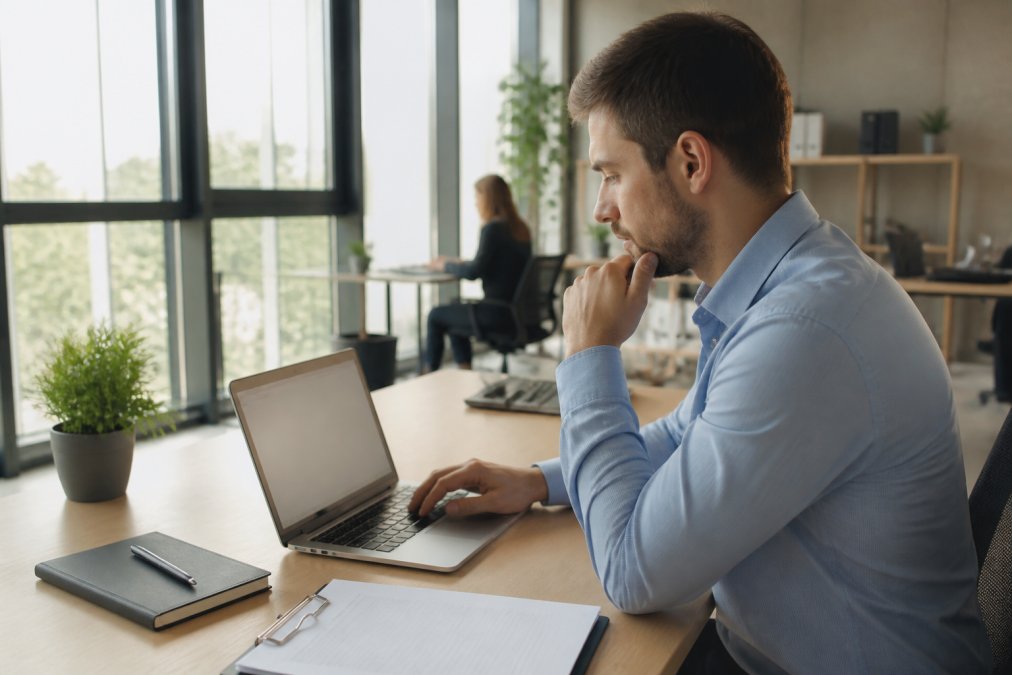 Nahaufnahme eines Laptop-Bildschirms mit grünem Schloss-Symbol in der Adressleiste und HTTPS-Anzeige, modernes Büro mit natürlicher Beleuchtung im Hintergrund