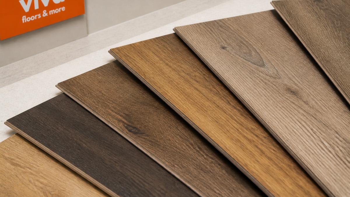 Close-up of luxury vinyl plank flooring samples showing various wood-grain finishes and textures arranged on a light surface