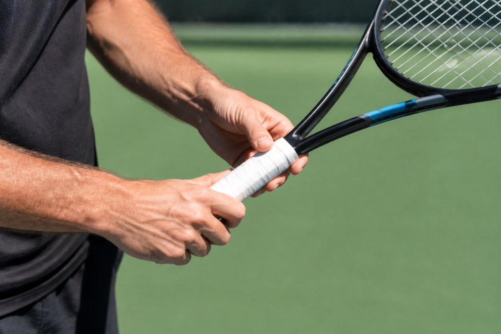 Tennis player adjusting to a continental grip as part of the step by step tennis serve grip change for kick serve
