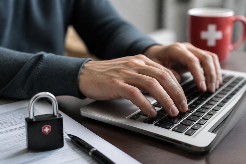Nahaufnahme einer Laptop-Tastatur mit leuchtenden Schloss- und Sicherheitssymbolen auf dem Bildschirm. Das Bild zeigt eine blaue Verschlüsselungsvisualisierung mit Zahlencodes und Sicherheits-Icons. Hintergrund leicht unscharf, professionelle Beleuchtung.