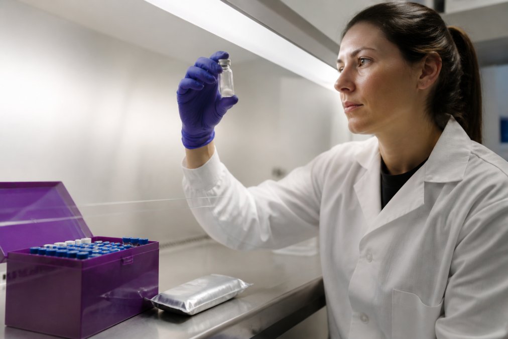 Researcher examining a lyophilized peptide vial to evaluate neat storage stability versus dmso vs neat conditions.