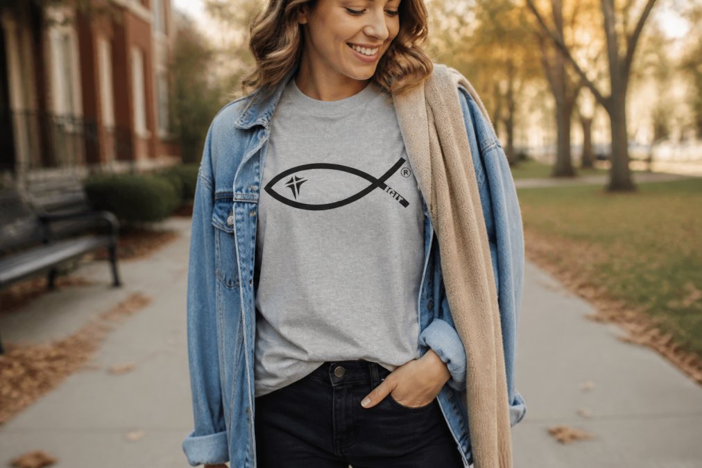 A styled outfit showing a scripture tee layered under an oversized denim jacket with a lightweight cardigan draped over one shoulder, demonstrating versatile fall layering for faith-based apparel