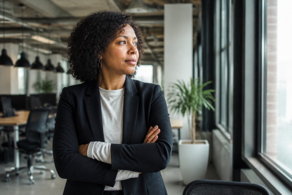 Professional wearing a political statement clothing work piece layered under a structured blazer in an office.