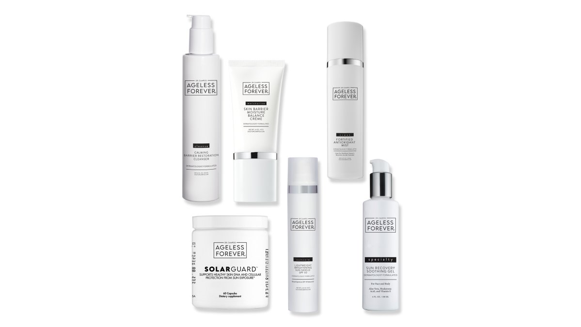Flat lay of the complete Sun Recovery Set products arranged on a clean white marble surface with soft natural window lighting, showing the cleanser, mist, gel, moisturizer, sunscreen, and supplement bottles