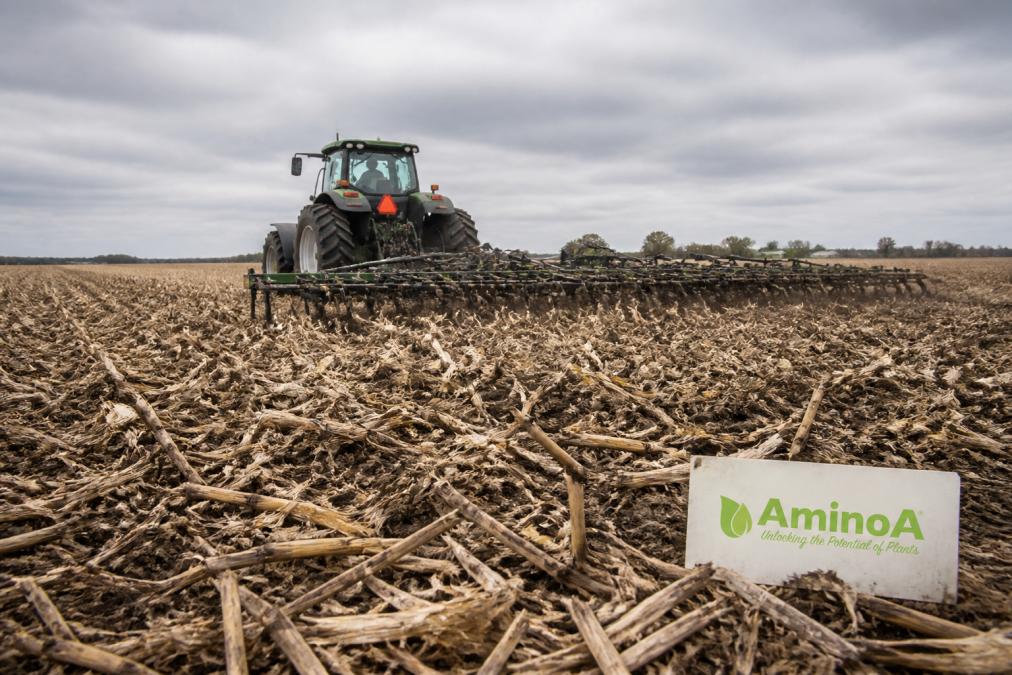 Tractor using minimal-disturbance equipment for sustainable soil management on a field with crop residue