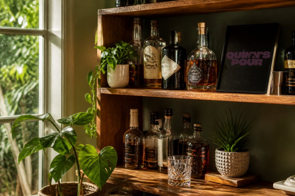 Craft spiced rum bottles and a potted plant on a shelf to inspire sustainable spirits at home.