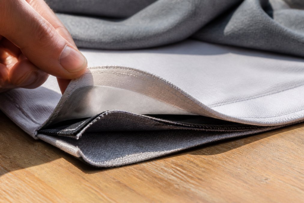Close-up of layered fabric construction showing the triple-layer underarm protection with moisture-wicking fibres and protective barrier visible in natural light
