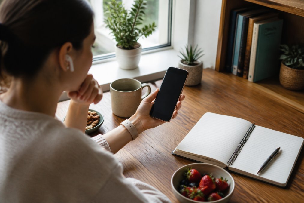 Person reviewing personalized data on a smartphone to find sympto alternatives health tracking solutions.