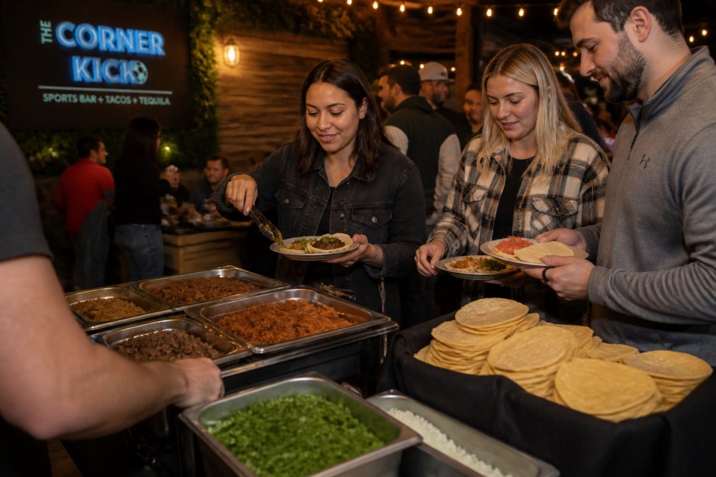A vibrant taco bar spread at a private event featuring locally made yellow corn tortillas, three seasoned meat options in stainless steel warming containers, fresh cilantro garnish, and guests serving themselves in casual evening lighting