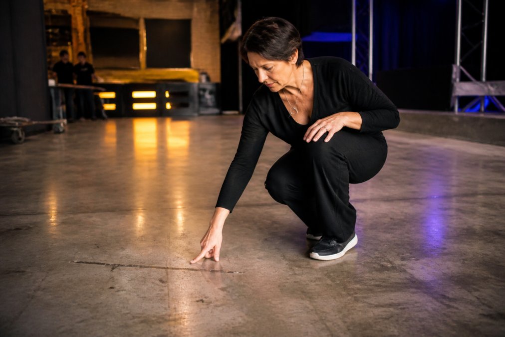 Petra Keizer inspecting a dance floor surface for levelness and proper preparation before installation