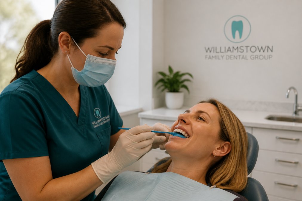 Dentist applying protective gel during teeth whitening sensitive teeth treatment in a modern surgery