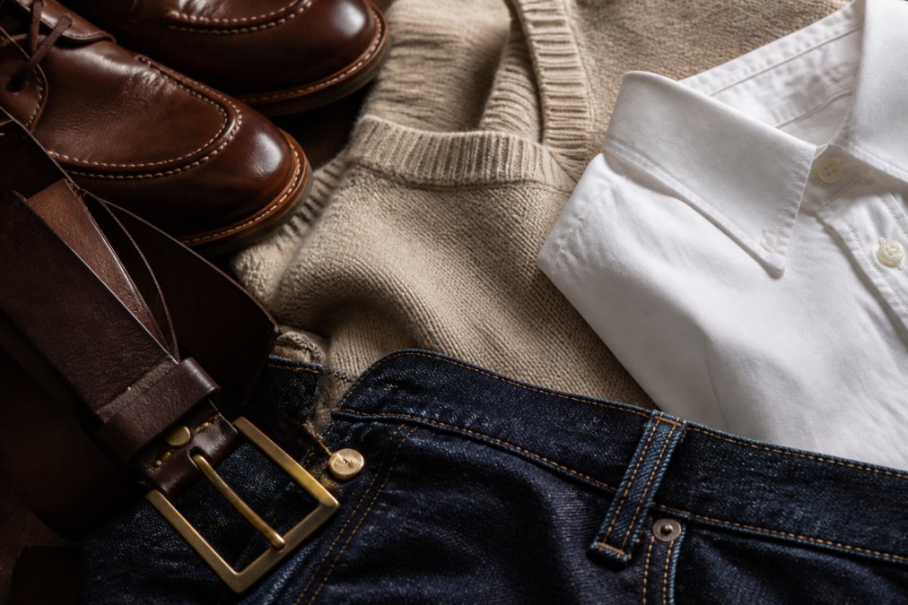 Close-up detail shots of premium materials showing genuine leather belt and shoes with visible stitching, cashmere sweater weave texture, high-quality white cotton button-up fabric, and dark denim stitching demonstrating craftsmanship