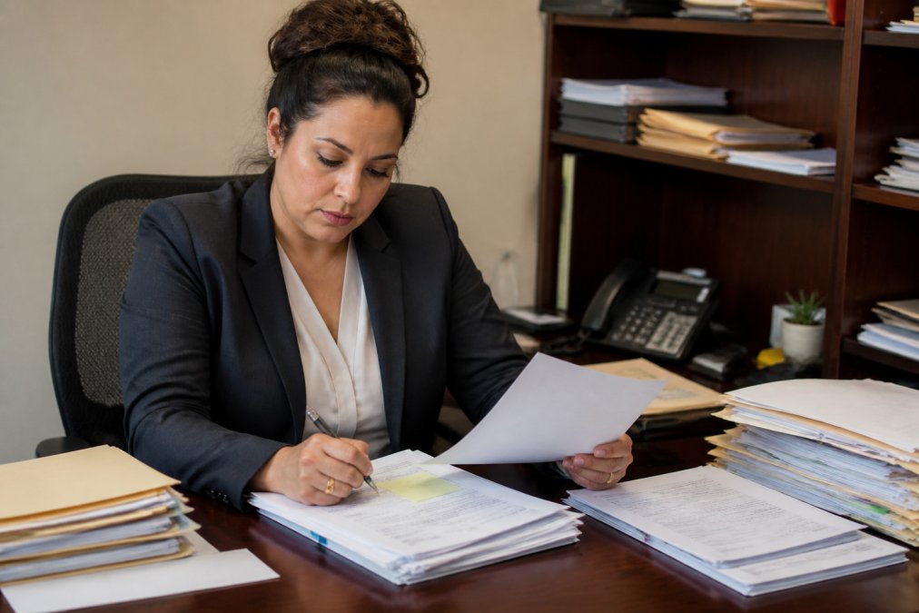 Real estate professional reviewing property deeds during the title curative process at a desk