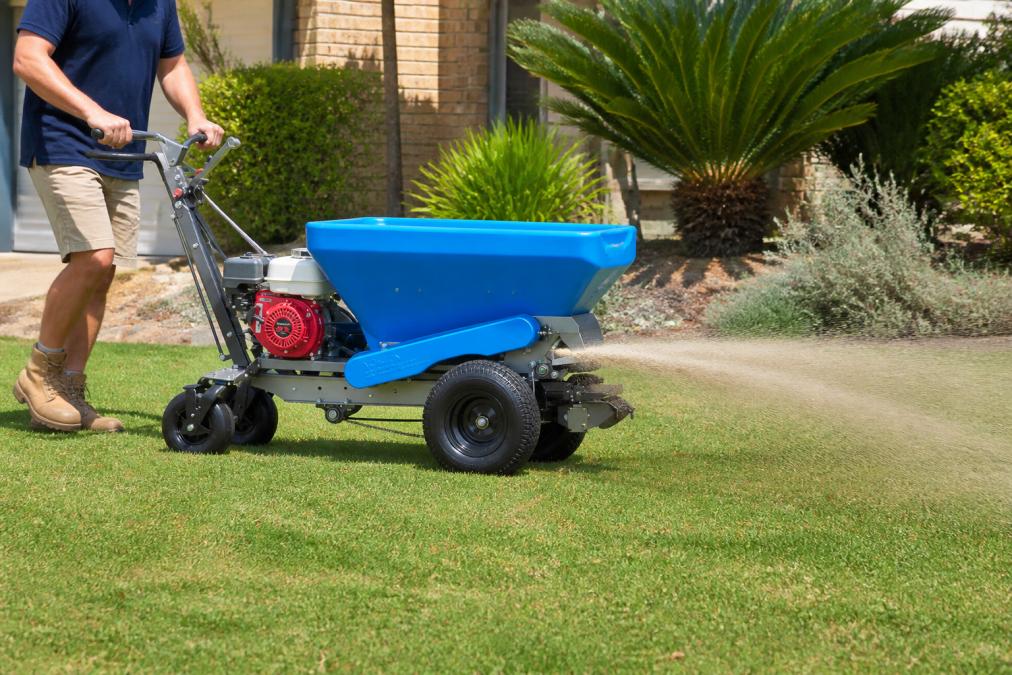 Diagram showing how to top-dress lawn quickly using an ECO250-S sand spreader for even coverage on residential grass.