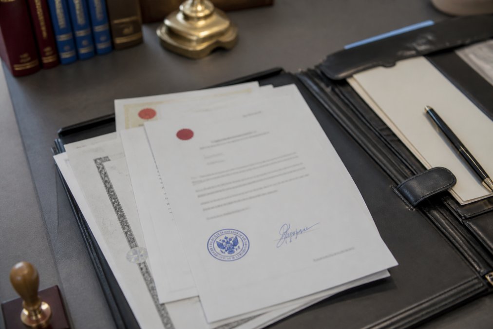 Documentos traducidos con sello oficial visible y firma del traductor jurado, organizados sobre escritorio profesional con carpeta de expediente