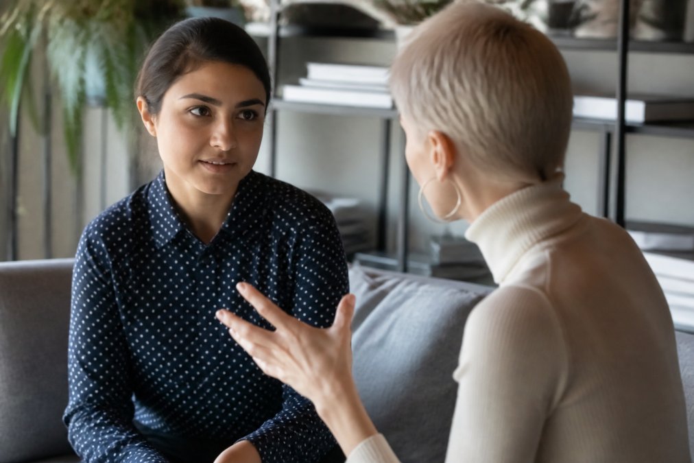Two professionals practicing active listening during training as a coach in a modern office setting