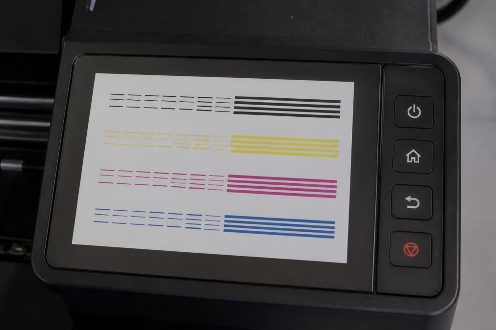 DTF printer control panel displaying nozzle check results with clear comparison between blocked nozzles showing gaps and healthy nozzles with complete colour lines on printed test pattern