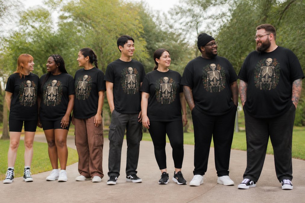 A diverse group of young adults wearing custom graphic tees in various sizes, from 2XS to 6XL, standing together in natural daylight to showcase inclusive sizing and fit across different body types and shapes