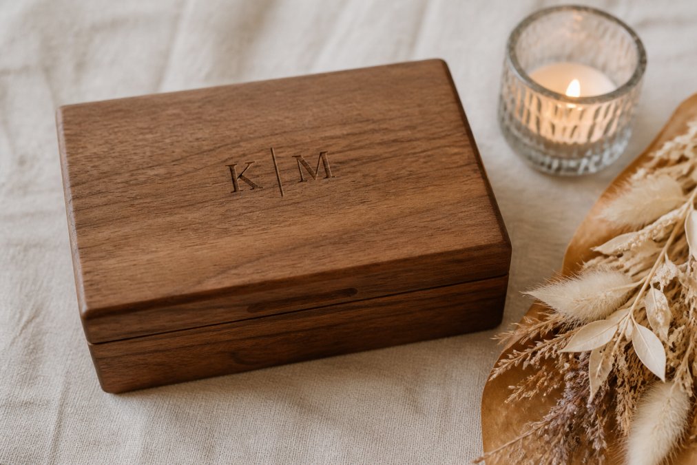 Handcrafted wooden keepsake box with engraved initials as unique wedding gifts resting on a linen tablecloth