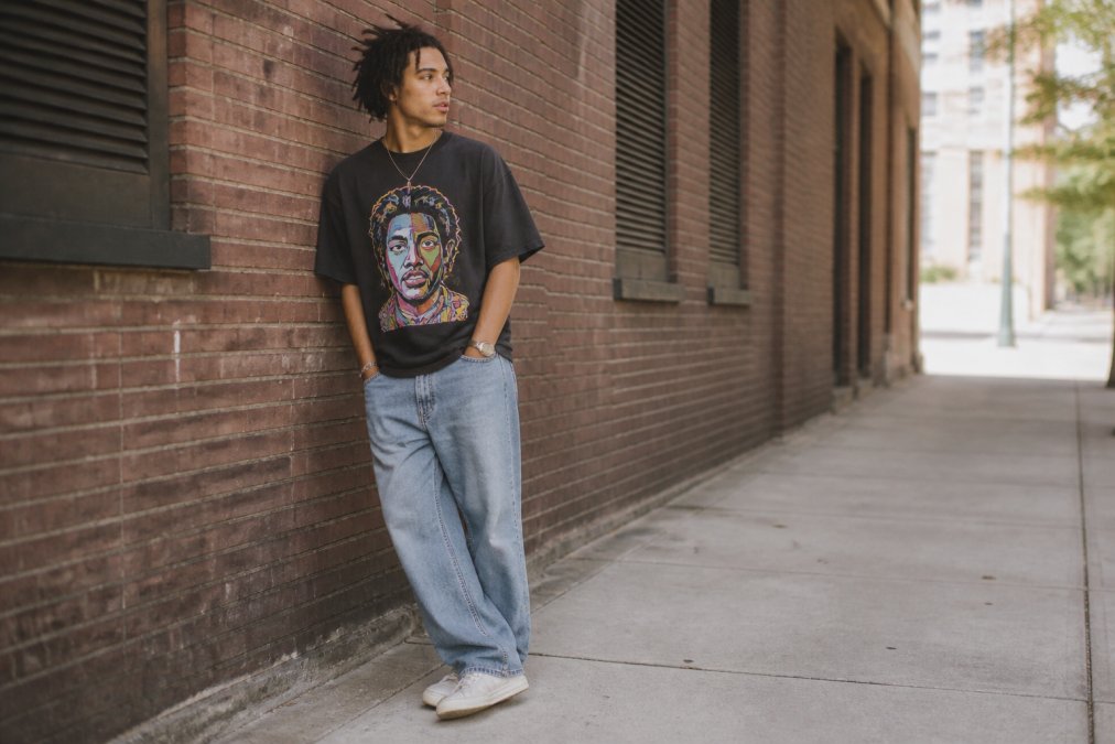 Young adult wearing an oversized vintage graphic tee and sneakers, a stylish look among urban outfitters alternatives.