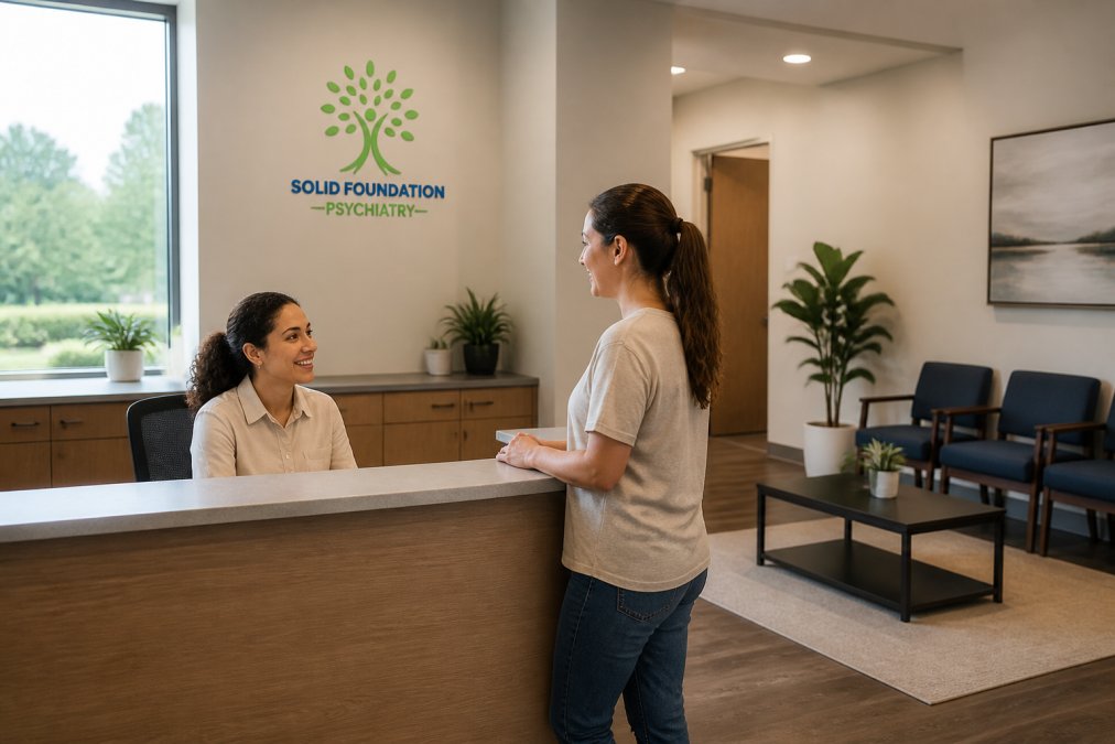 A calm, modern psychiatric clinic waiting area with natural light, a receptionist speaking with a patient at the front desk, and comfortable seating