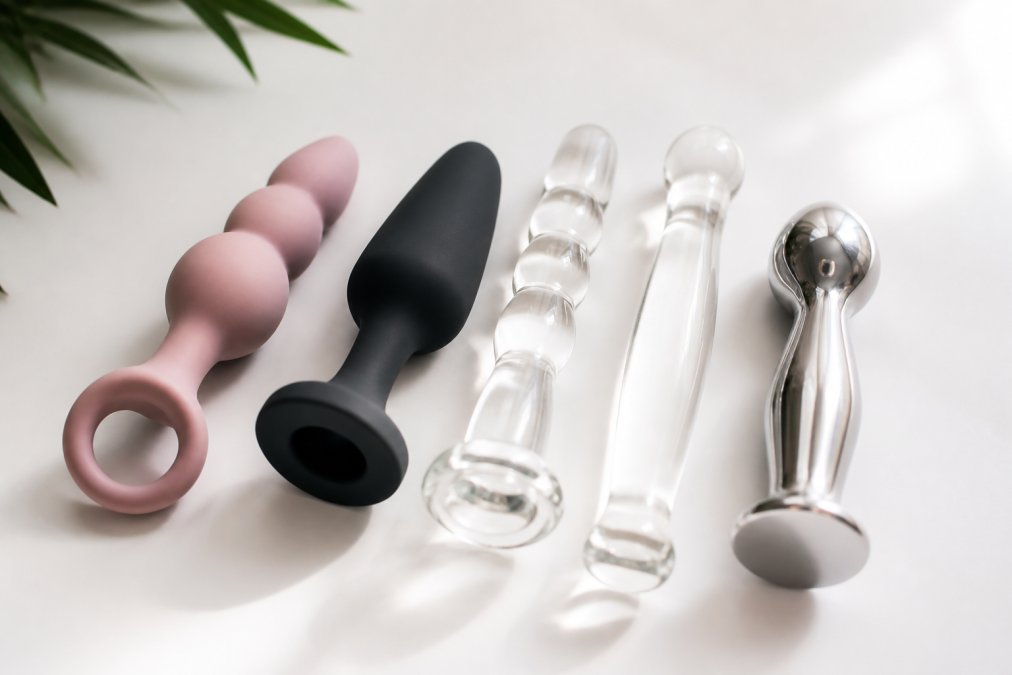 Close-up van verschillende veilige materialen zoals medische siliconen, borosilicaatglas en roestvrijstaal, netjes gerangschikt op een wit oppervlak met zachte, diffuse verlichting