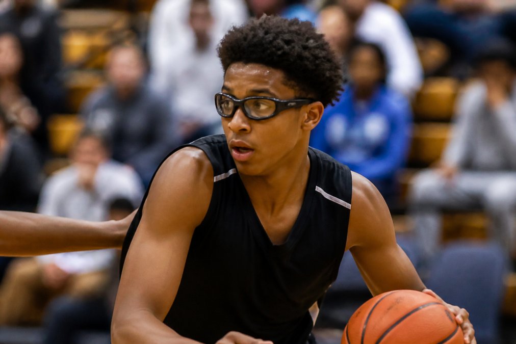 Athlete wearing prescription sports goggles during intense basketball match, secure fit visible on face with protective polycarbonate frames and wraparound design, showing clear vision and stability during active play