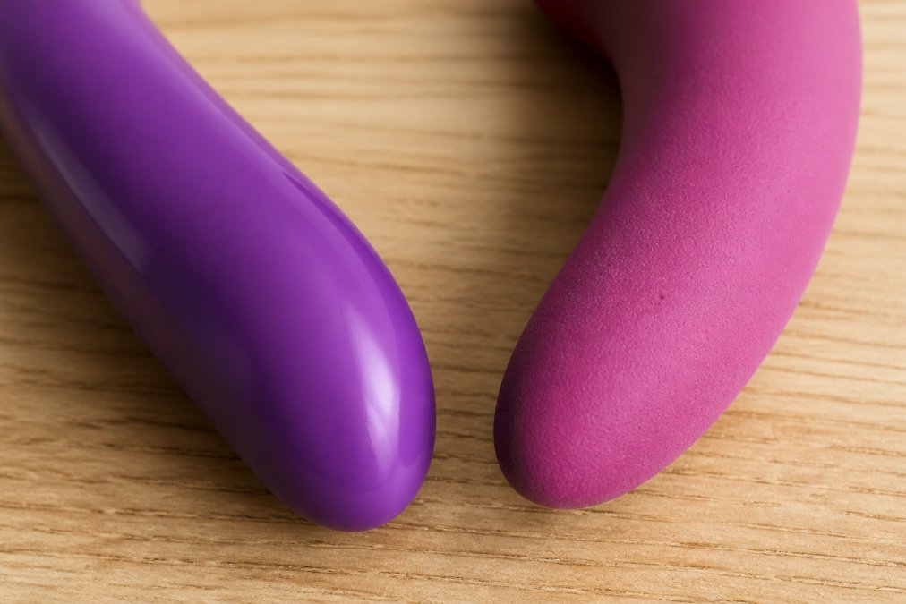 Close-up van twee materialen naast elkaar, een glad, glanzend siliconen oppervlak tegenover een mat PVC oppervlak met zichtbare poriën, onder natuurlijk licht