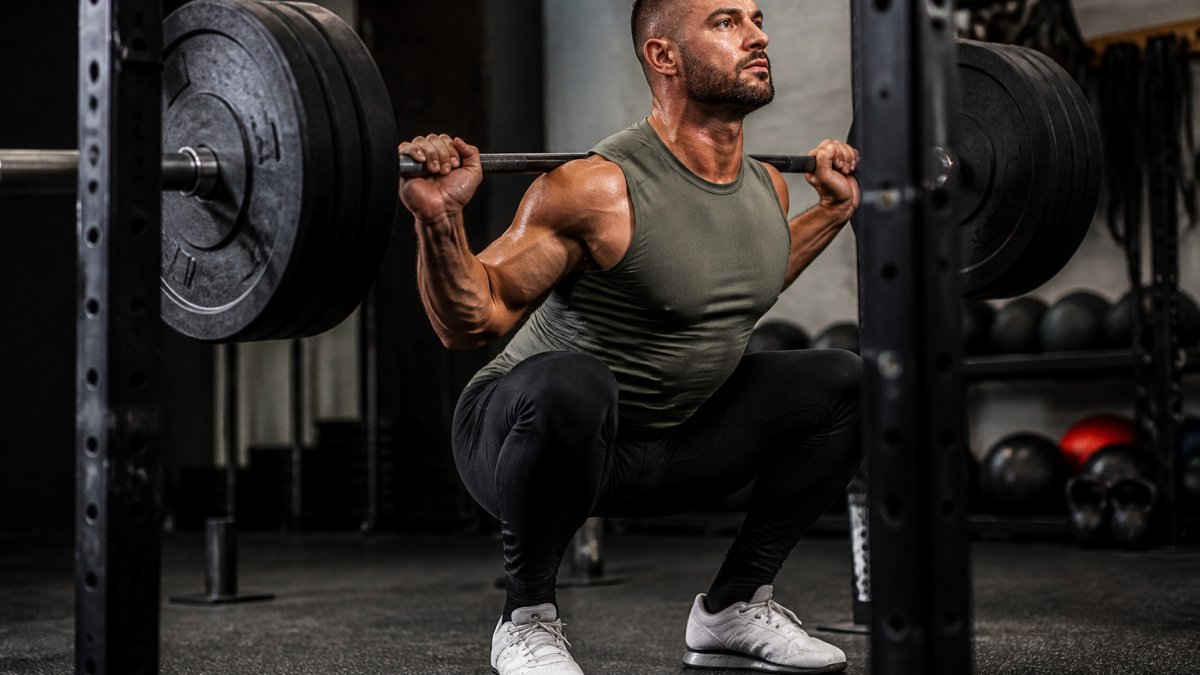 Athlete performing a heavy squat in supportive gym wear, showing secure fit and sculpting silhouette during intense movement