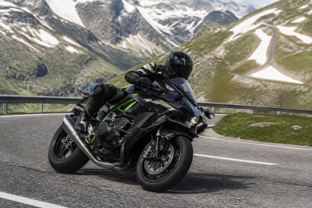 Motorrijder op bergachtige route met zichtbare inspanning in het terrein, landschap met hellingen en bochten, dramatische bergachtige setting