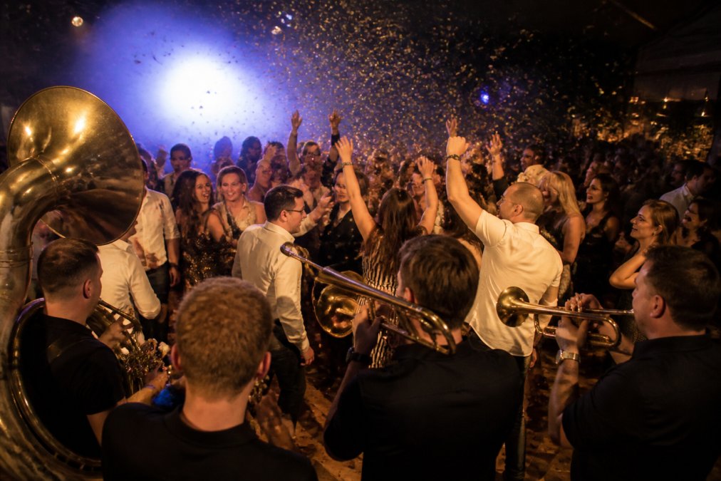 Energieke brassband op een bedrijfsfeest zorgt voor dansvloer energie, wat verklaart waarom live muziek op bedrijfsfeest