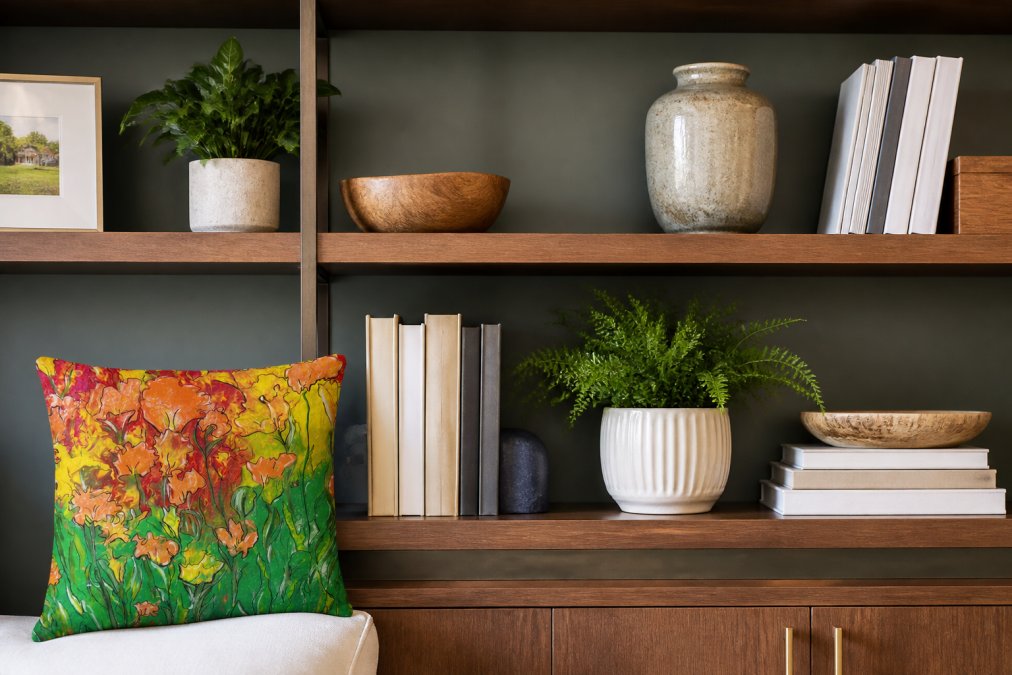 Close-up of designer-styled shelf with curated objects, accent pillows, books, plants, and meaningful pieces arranged with negative space and intentional composition
